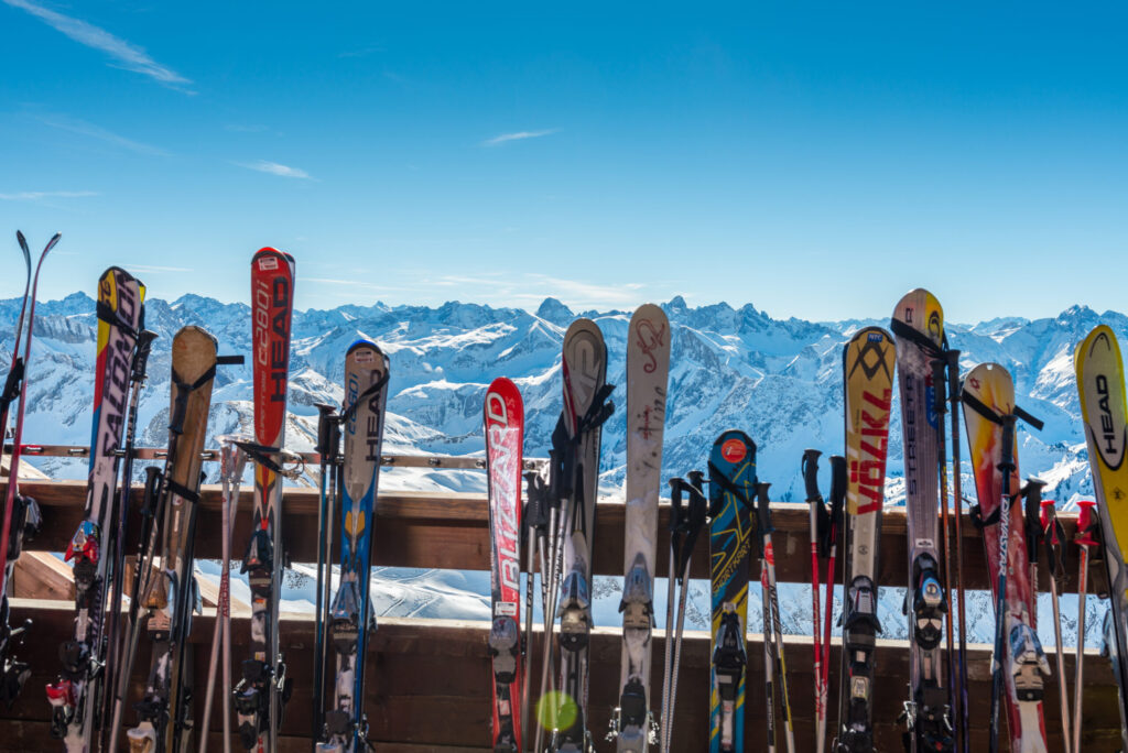 Skis leaning on a balcony overlooking the Alps